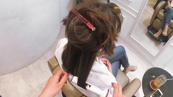 カールアイロンで毛先を巻く様子