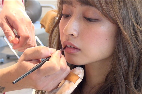 リップをブラシで塗る