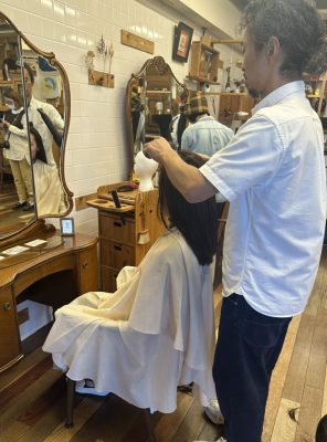 ウイッグにカットを施すREMILIO代表