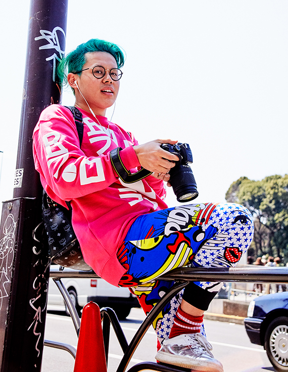 カラフルな出で立ちでカメラを構える彼のライバルは桜