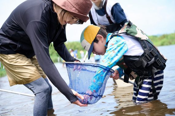 親子で水生生物とのふれあいを楽しむ様子